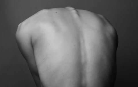 Greyscale image of a person's back.